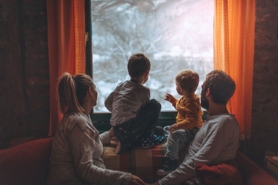 Family looking out their home's window.